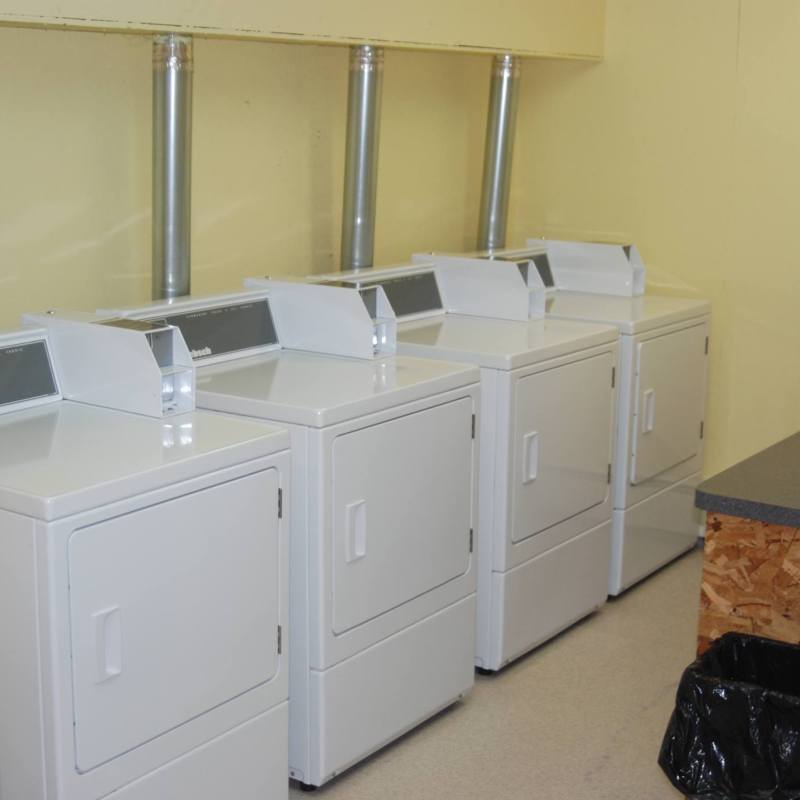 Laundry Facility. The machines are coin operated and there is a folding table.