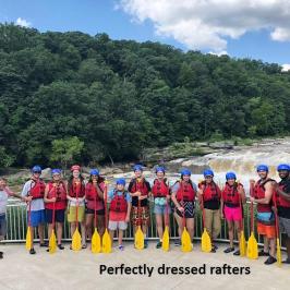 Huge group of rafters smiling with their paddles