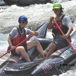 Two people in a faltable raft paddling on white water rapids