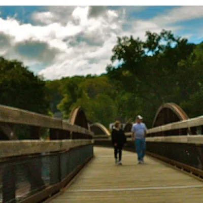 Two people crossing the bridge over the Yough River